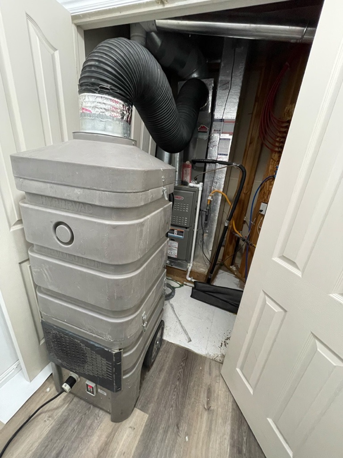 Professional negative-air duct cleaning equipment connected near a furnace