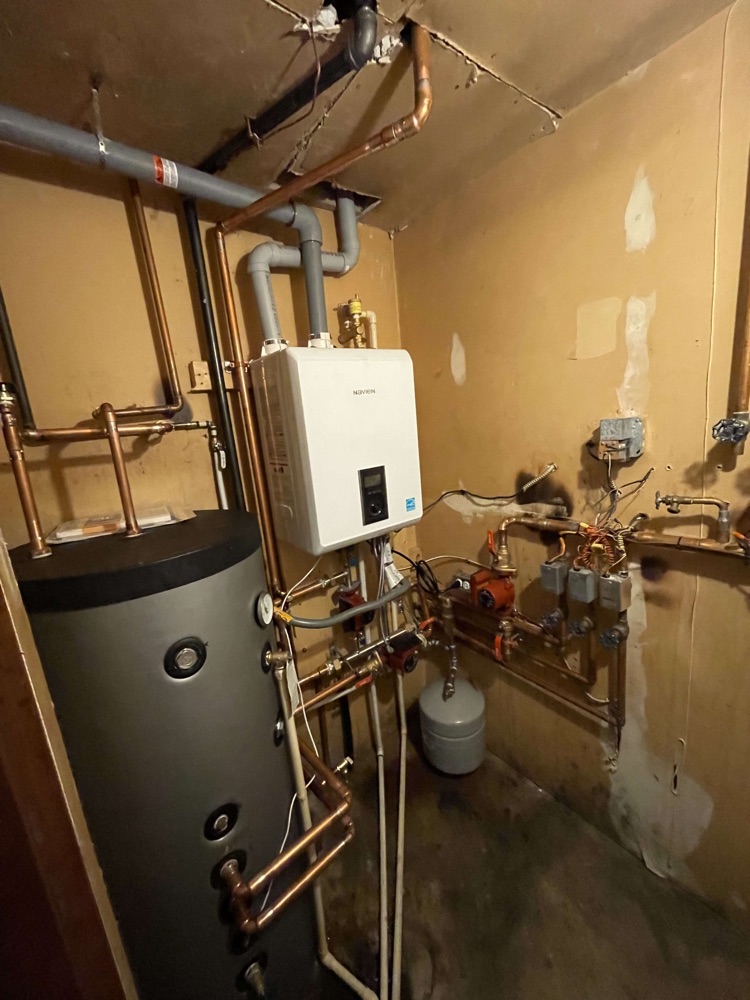 Wall-mounted Navien hydronic heating system with storage tank and copper piping