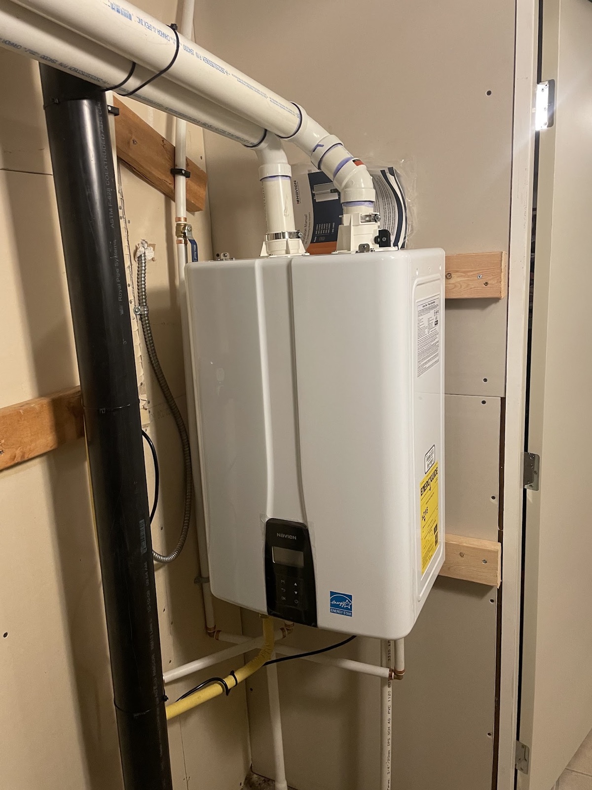 Navien tankless water heater installed in a compact mechanical closet