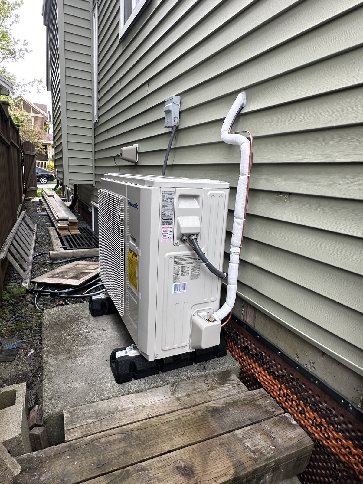 Residential outdoor heat pump installed beside a home