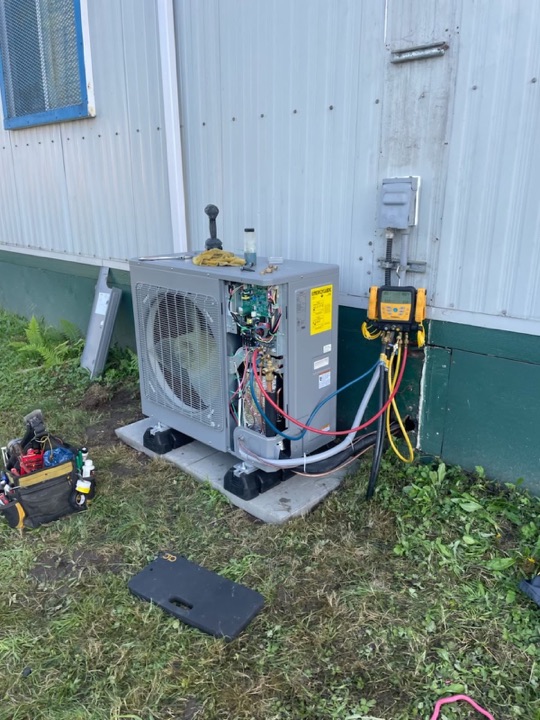 Outdoor cooling equipment connected to HVAC gauges for system testing