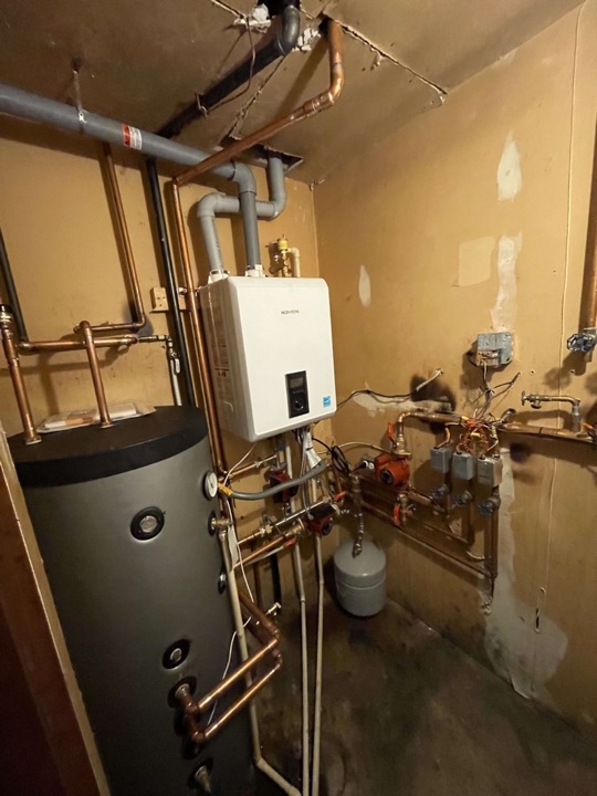 Wall-mounted Navien hydronic heating system with storage tank and copper piping