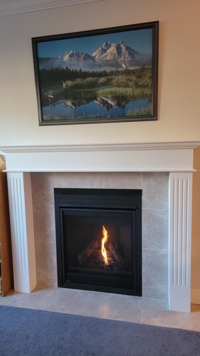 Residential gas fireplace operating inside a finished living room mantel