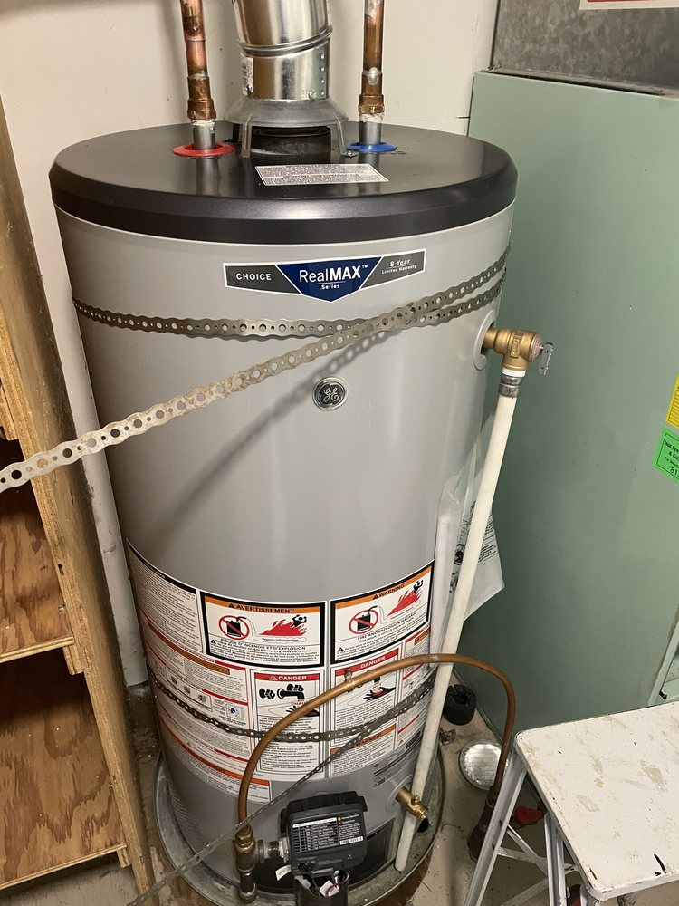 GE gas hot-water tank installed beside residential HVAC equipment